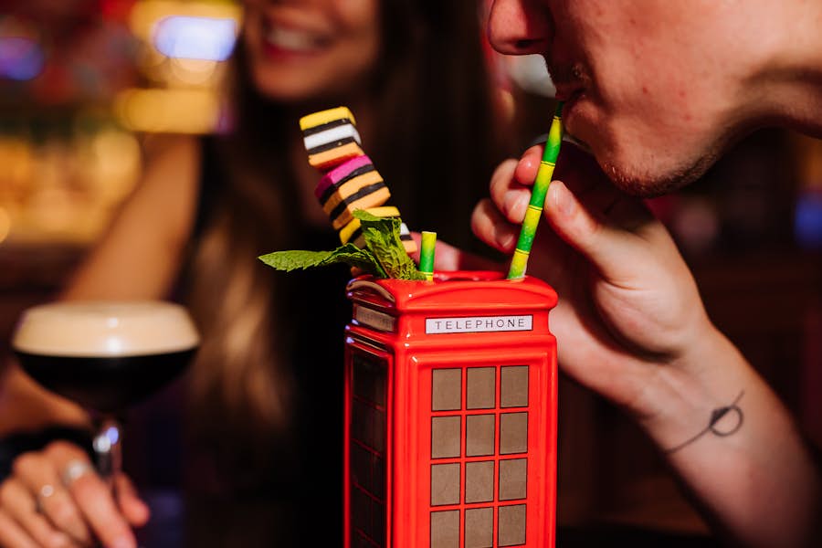 Close up of a man drinking the London Calling cocktail
