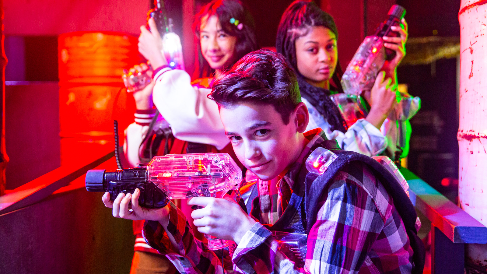 Group of children holding laser tag guns and wearing laser tag vests