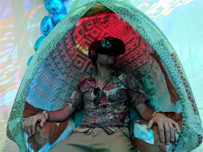 man sitting in 360 pod chair with VR headset on