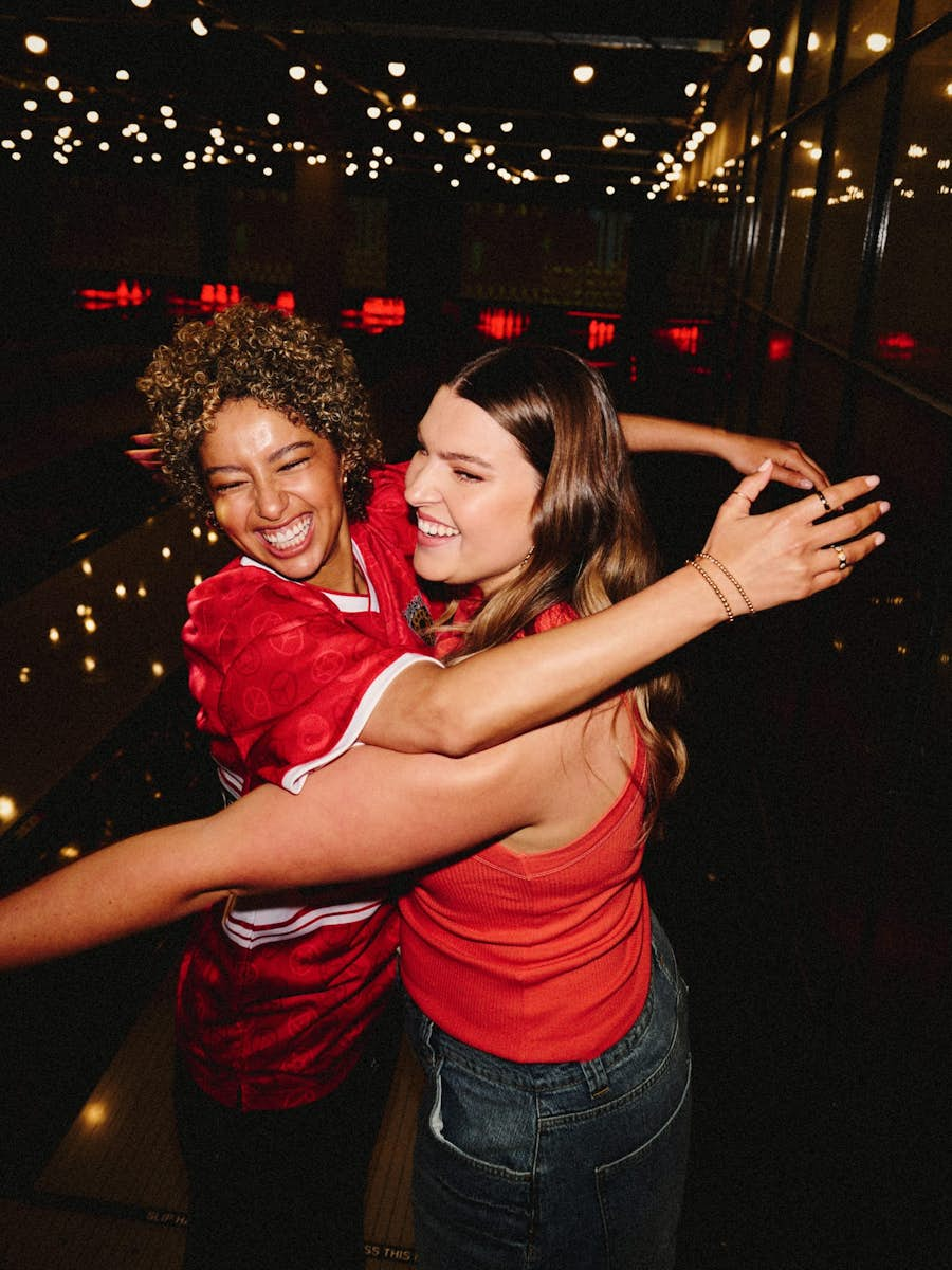 two girls hugging, smiling and enjoying their visit to strike