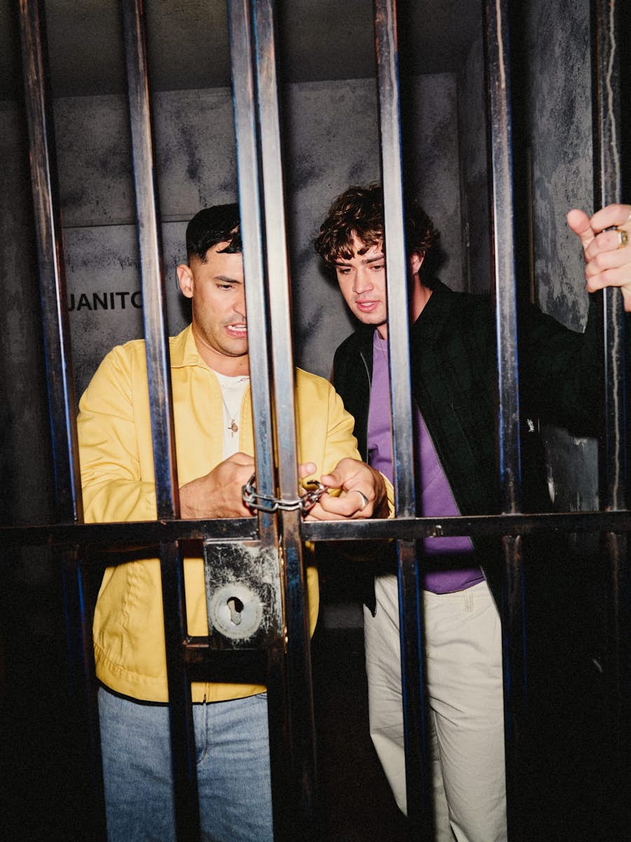 two men behind cell door trying to break the lock on the Breakout escape room