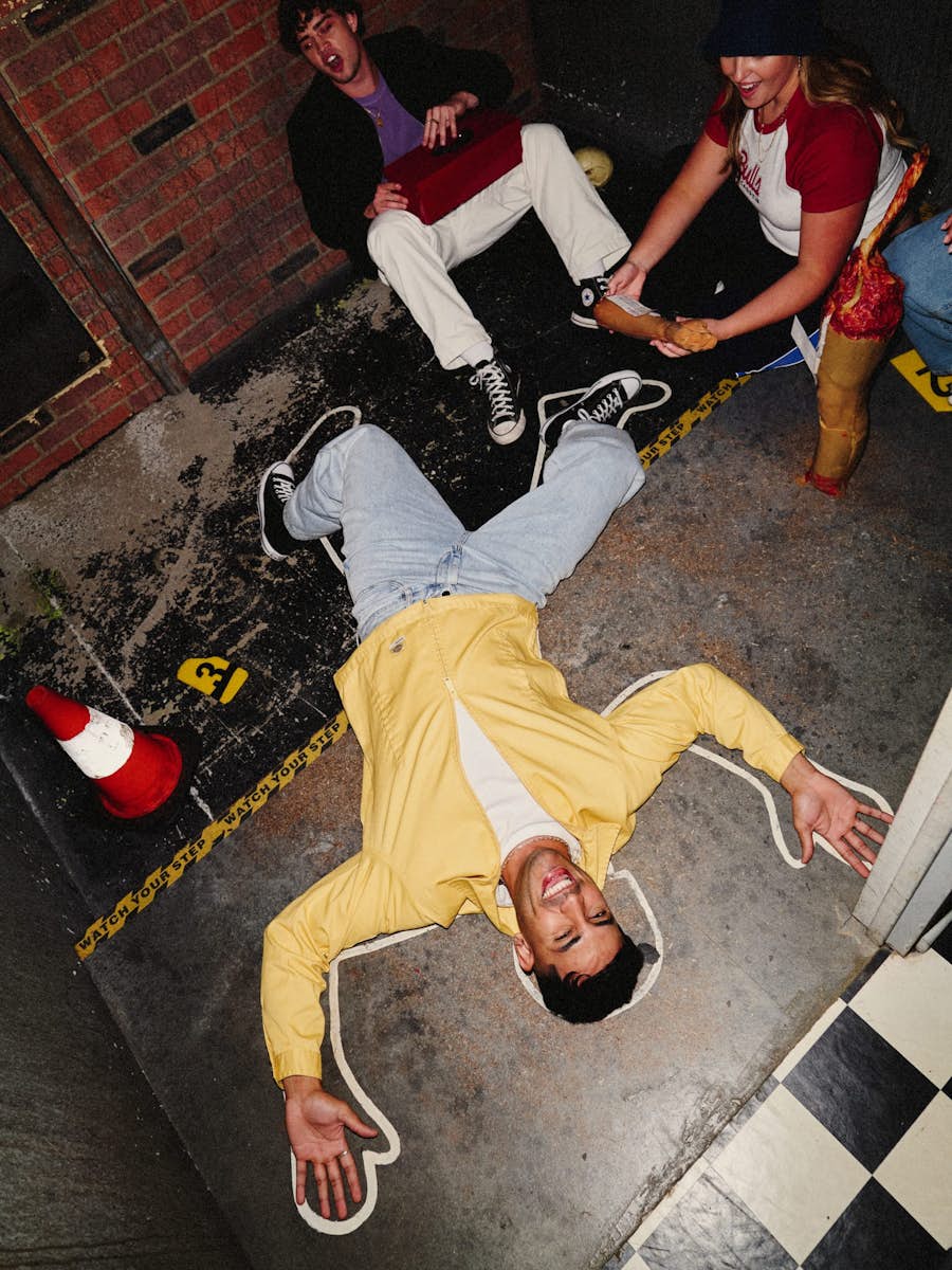 Man lying on the floor with chalk outline in the Forensic Escape room