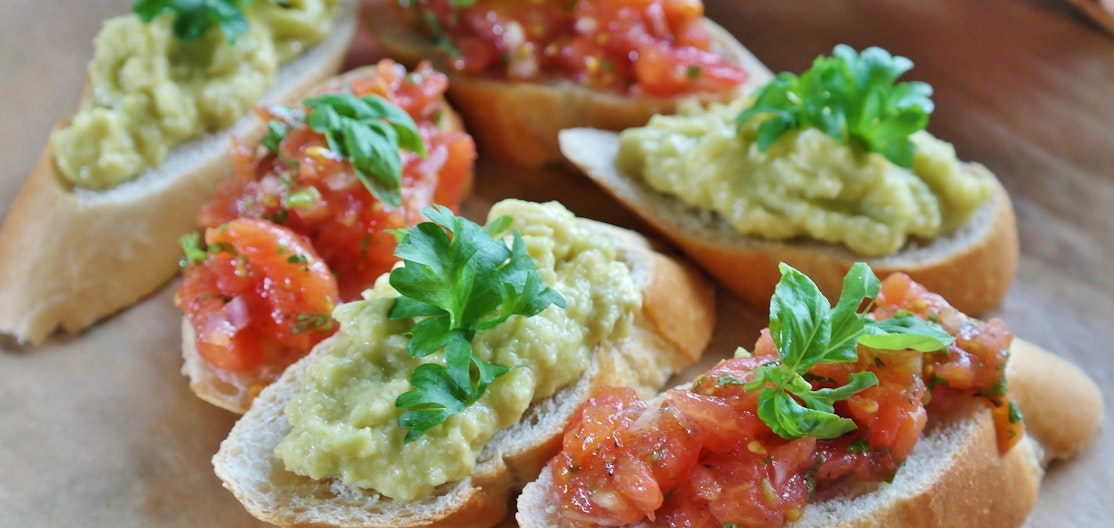 Bruschetta Zweierlei Bruschette, mit Tomate und mit Avocado, liegen für einen Apero bereit.