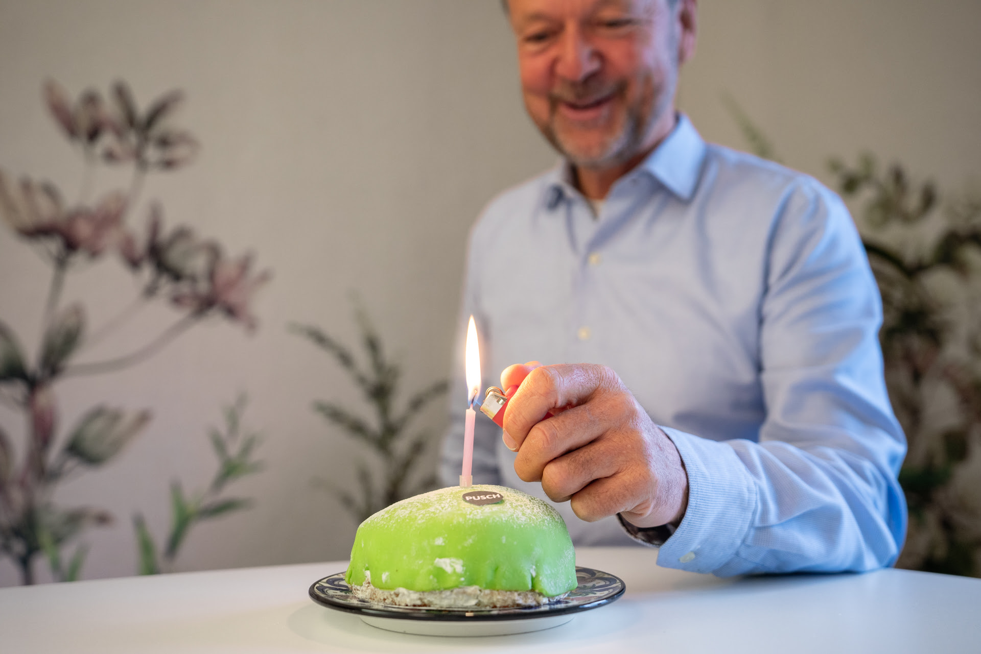 Felix Meier zündet eine Geburtstagskerze auf dem Pusch-Geburtstagskuchen an.