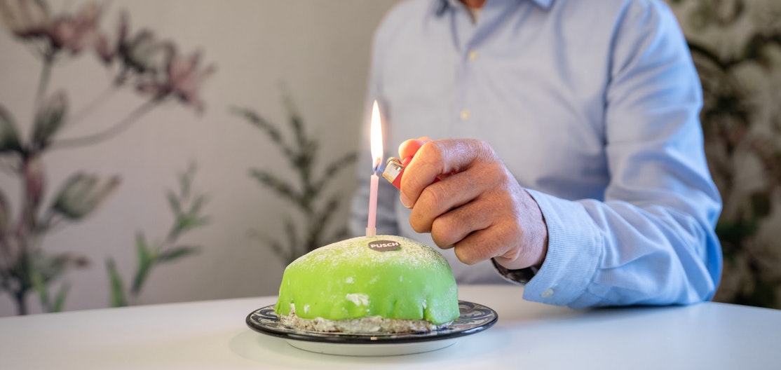 Pusch-Geburtstagskuchen Felix Meier zündet eine Geburtstagskerze auf dem Pusch-Geburtstagskuchen an.