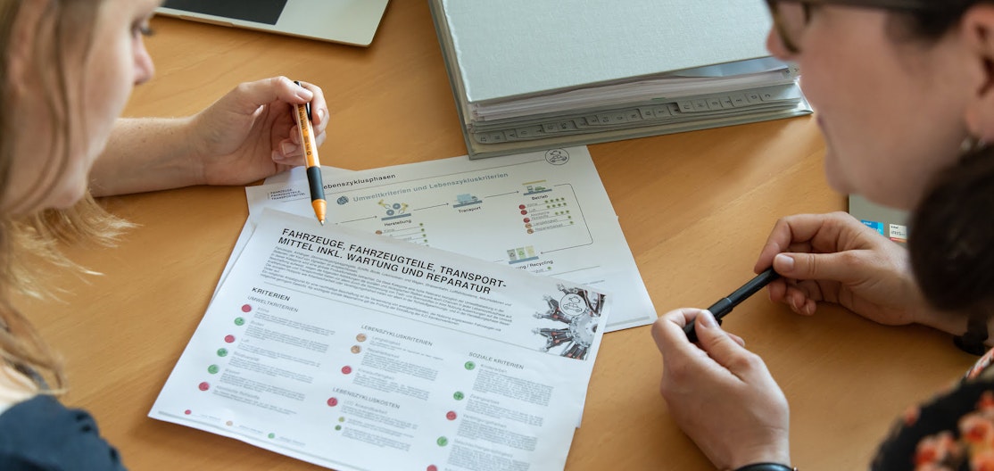 Beratung nachhaltige Beschaffung Zwei Frauen besprechen ein Merkblatt über die nachhaltige Beschaffung von Fahrzeugen