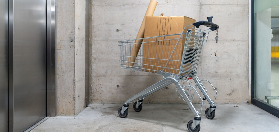 Einkaufswagen und Pakete Einkaufswagen steht vor einem Warenlift, darin liegen zwei Pakete.