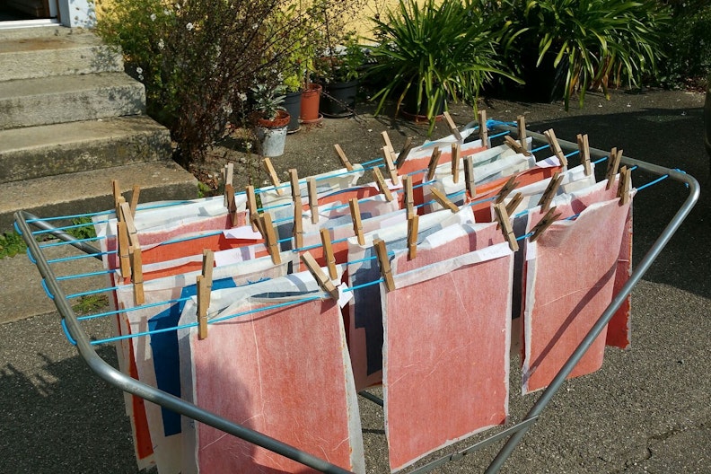 Wäscheständer, an dem rotes und blaues Papier zum trocknen hängt