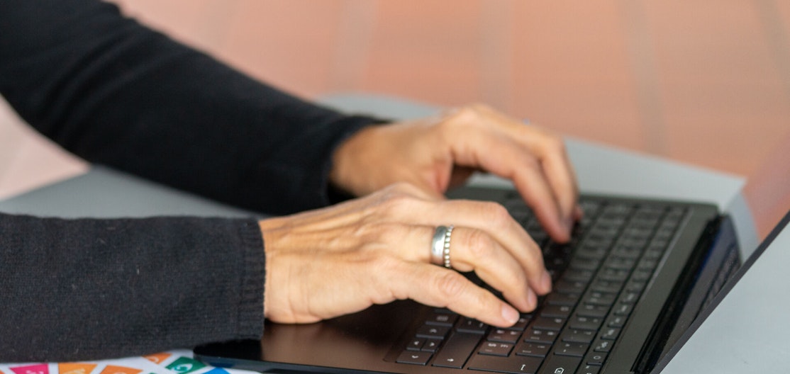 Laptop in Aktion Hände, die auf einer Laptop-Tastatur etwas notieren.