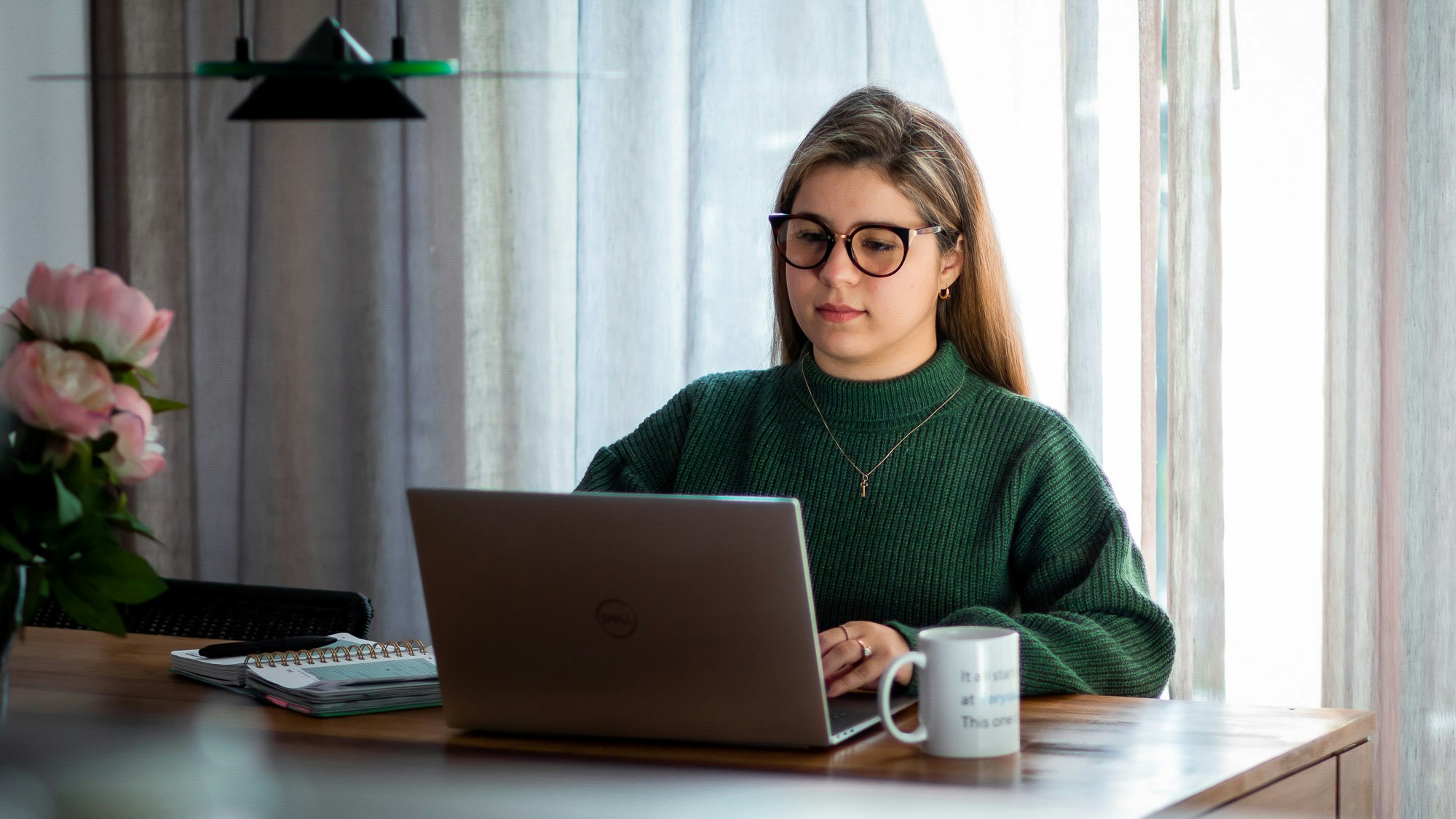 Lisandra working on her laptop at home