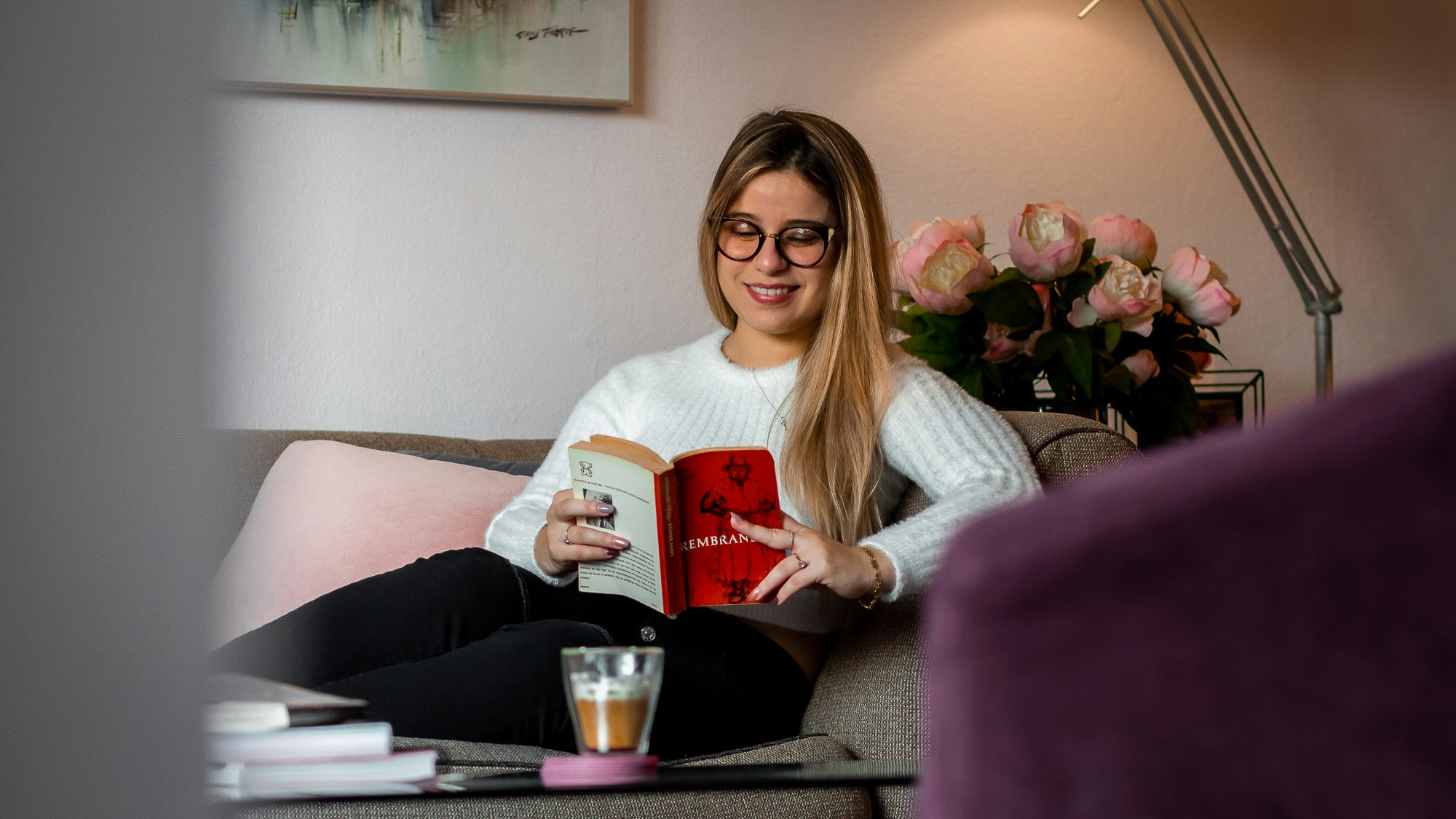 Lisandra Reading a book on a sofa