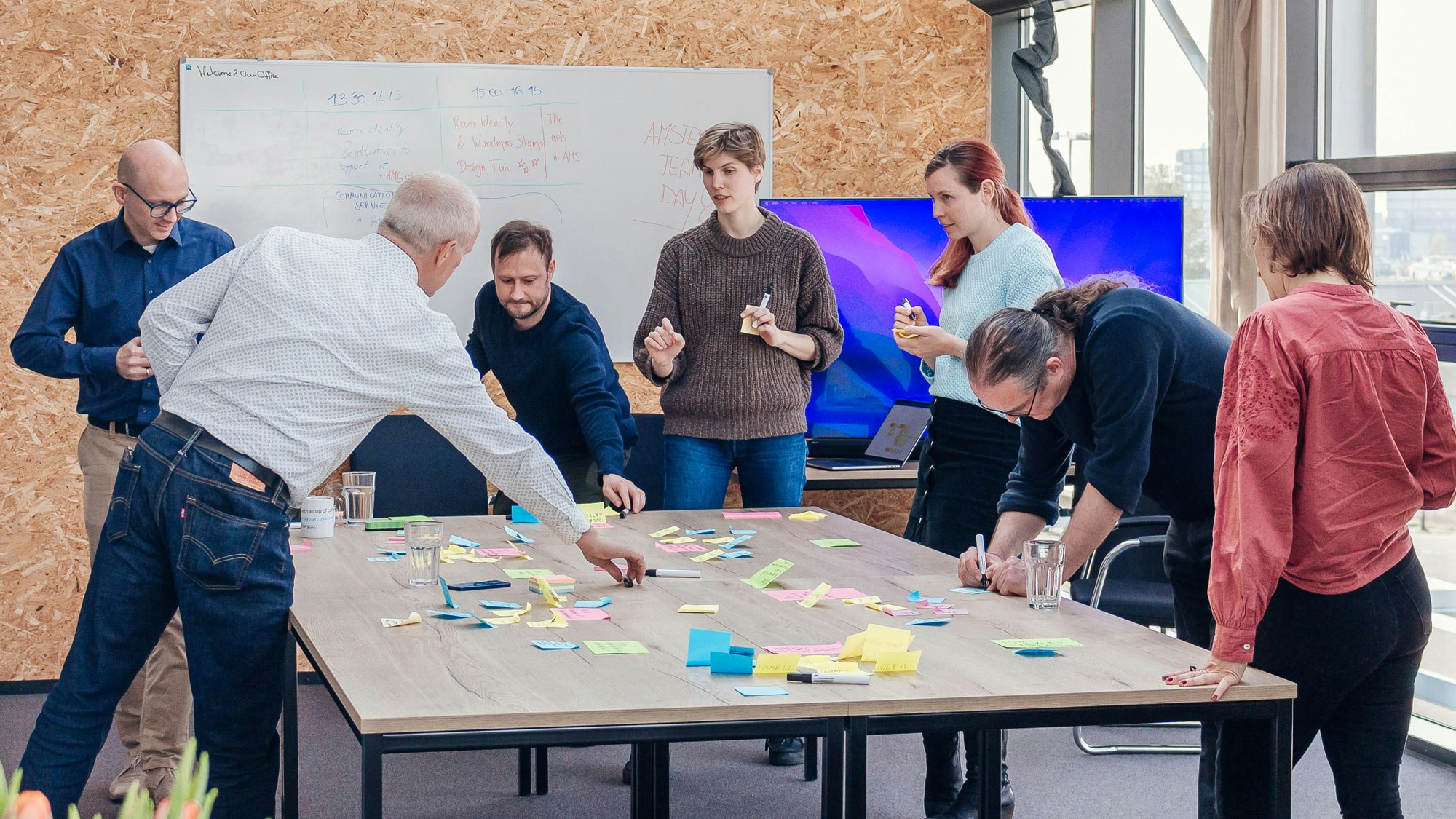 A group of 7 people in a workshop around a table