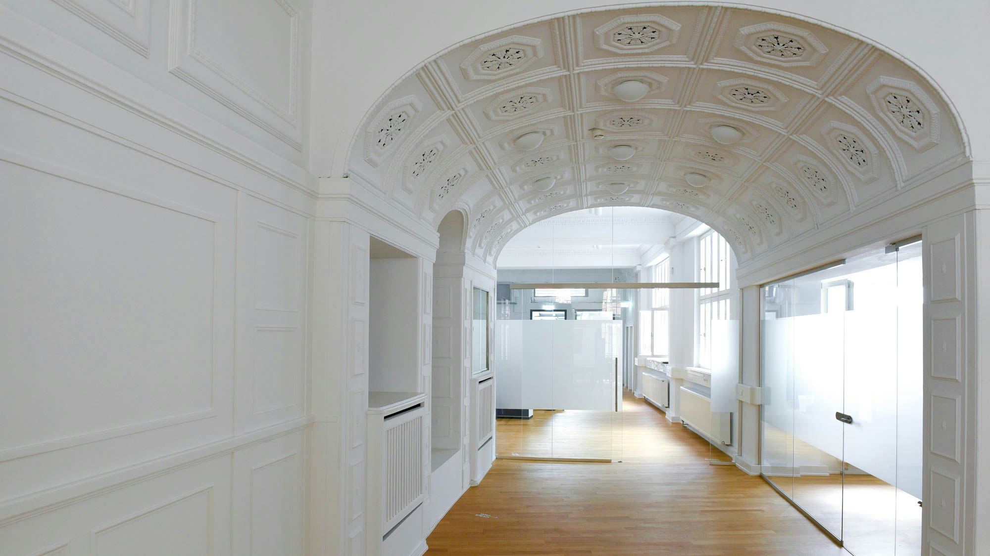 Bright office hall in Heidelberg old town with wooden floor.