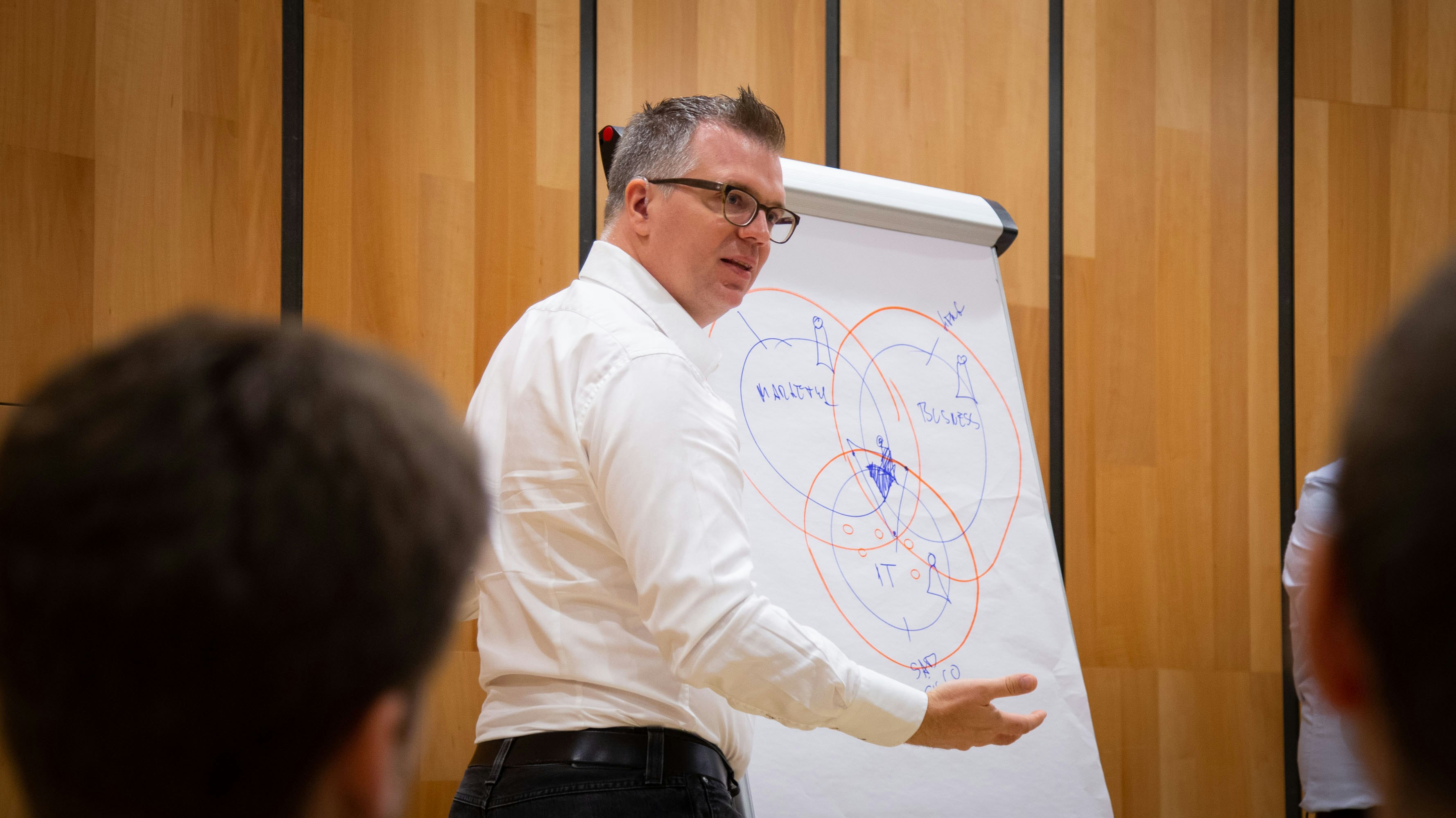 Jonathan Möller in einem weißen Hemd präsentiert vor einem Flipchart