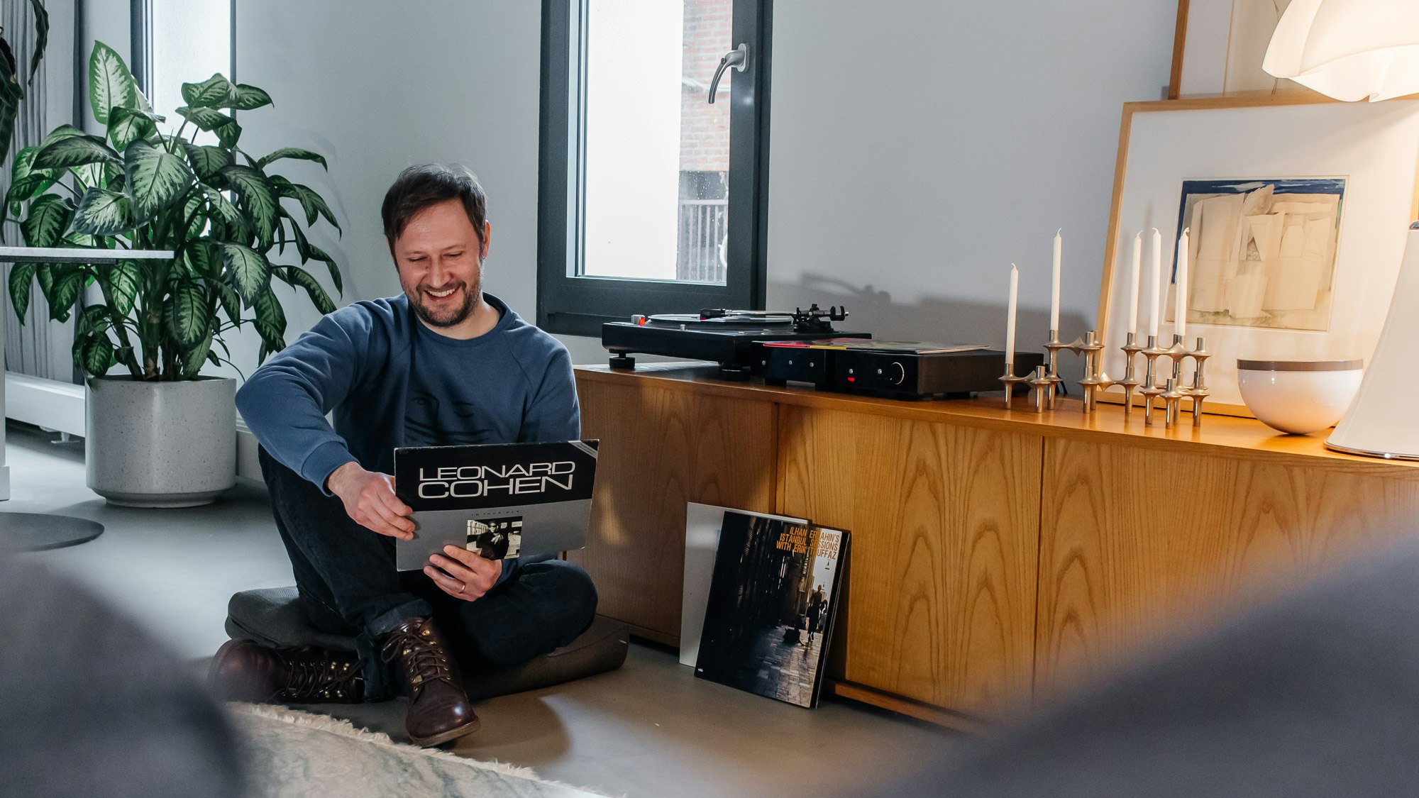 Diego looks at a vinyl of Leonard Cohen