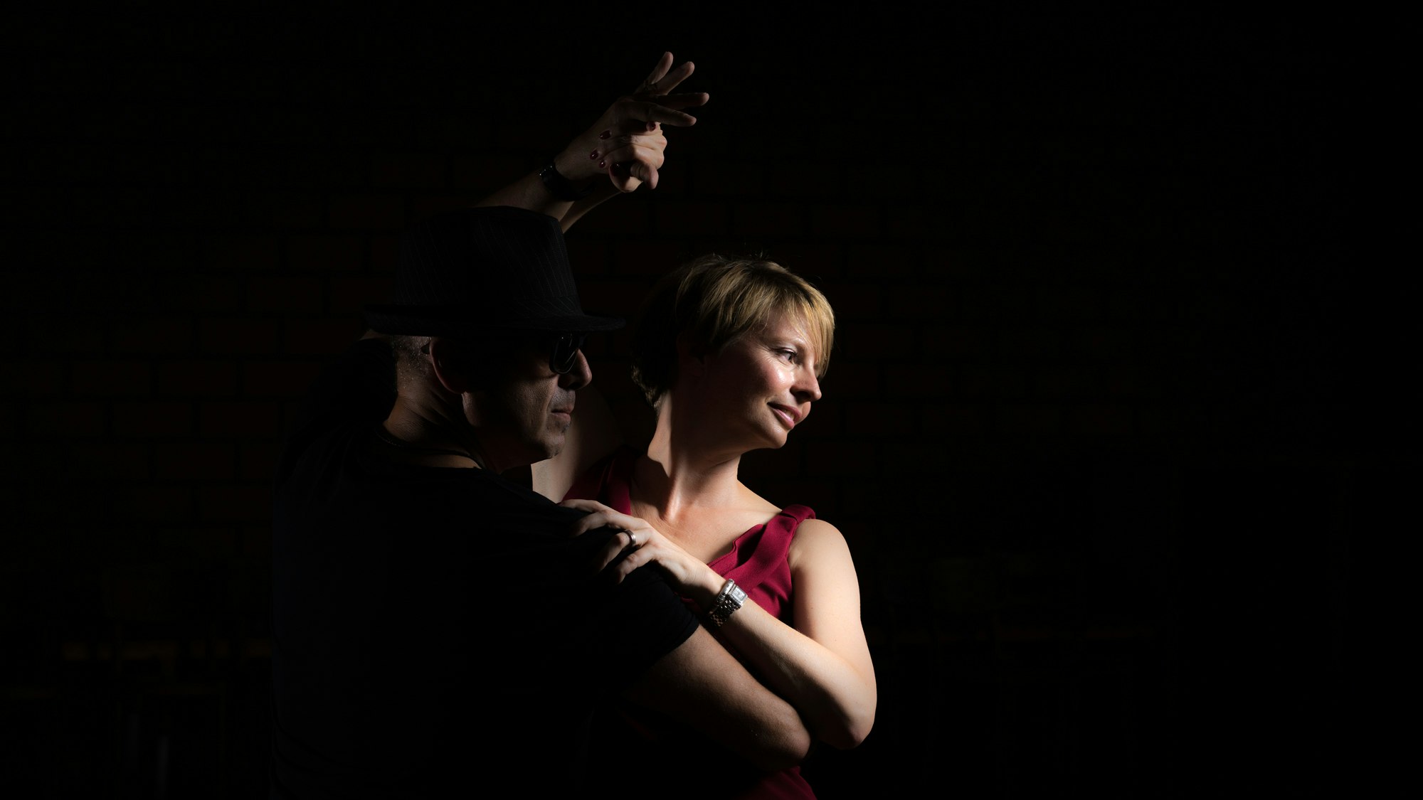 Jeannine tanzt mit einem Partner auf einem dunklen, stimmungsvollen Bild.