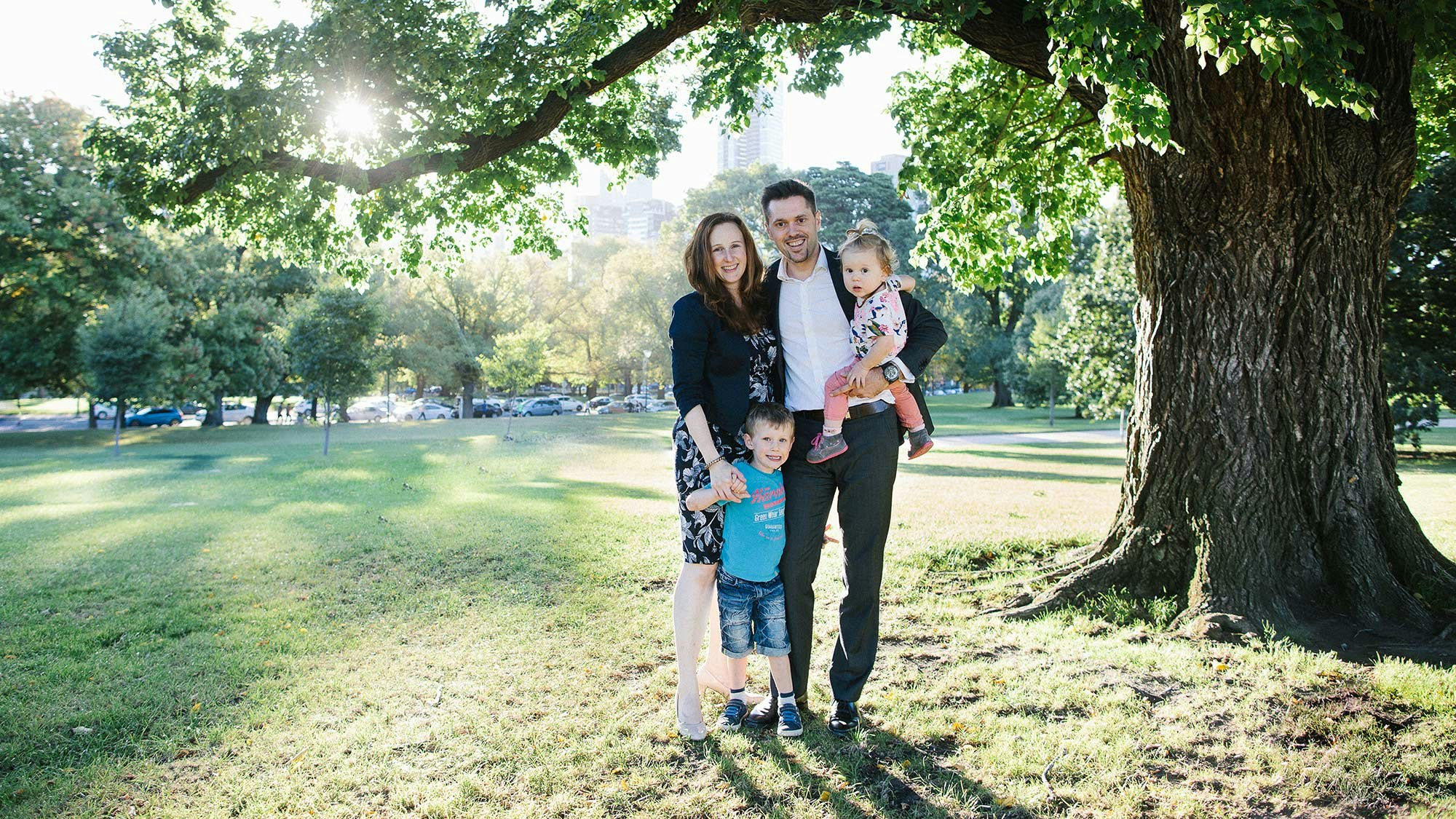 Bernhard with two kids and his wife under an old tree.