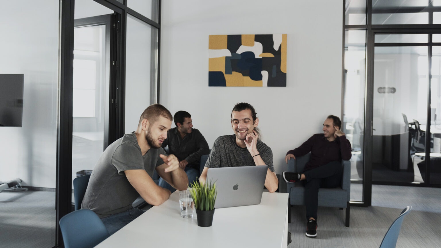 Several people around a laptop and couch