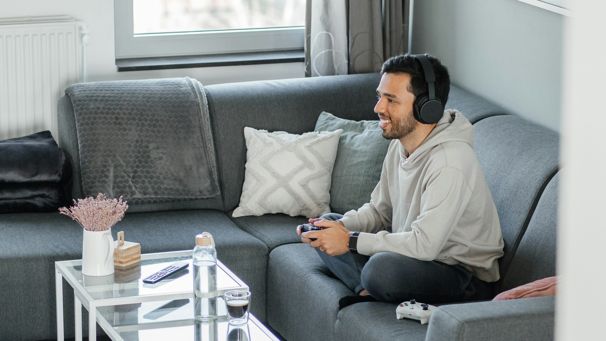 Felipe on a couch, with a headset and holding a controller in his hands