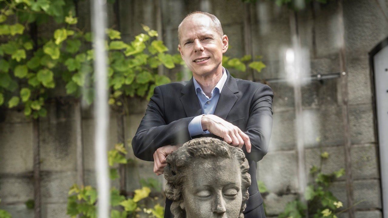 Christian Leeger in einem Garten mit einer Statue