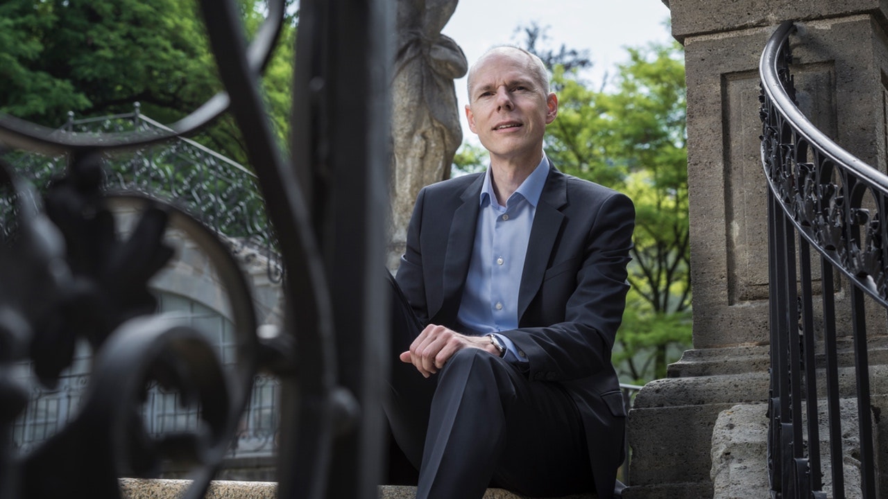 Christian Leeger sitzt auf einer Treppe in einem Stadtgarten