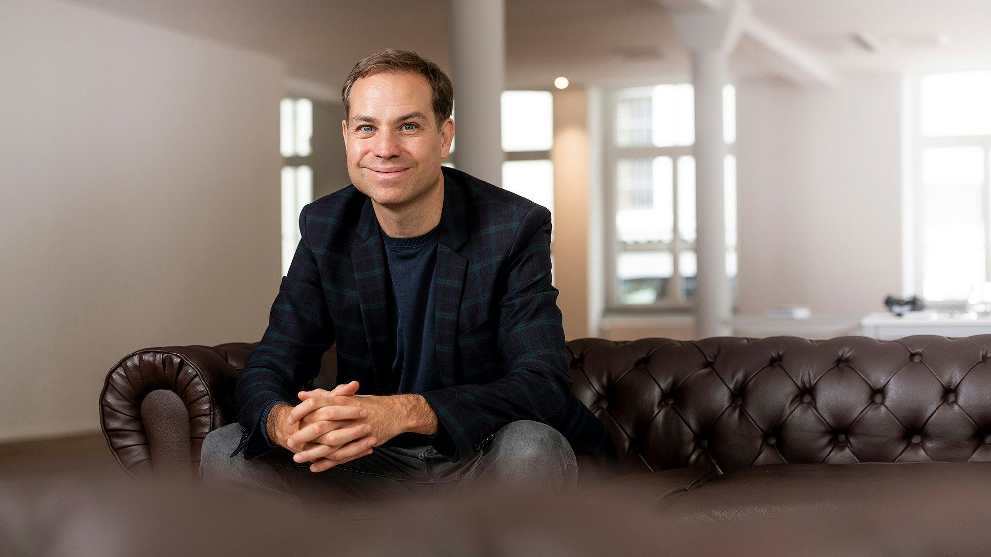 Tobias Felbecker sitzt auf einem Ledersofa
