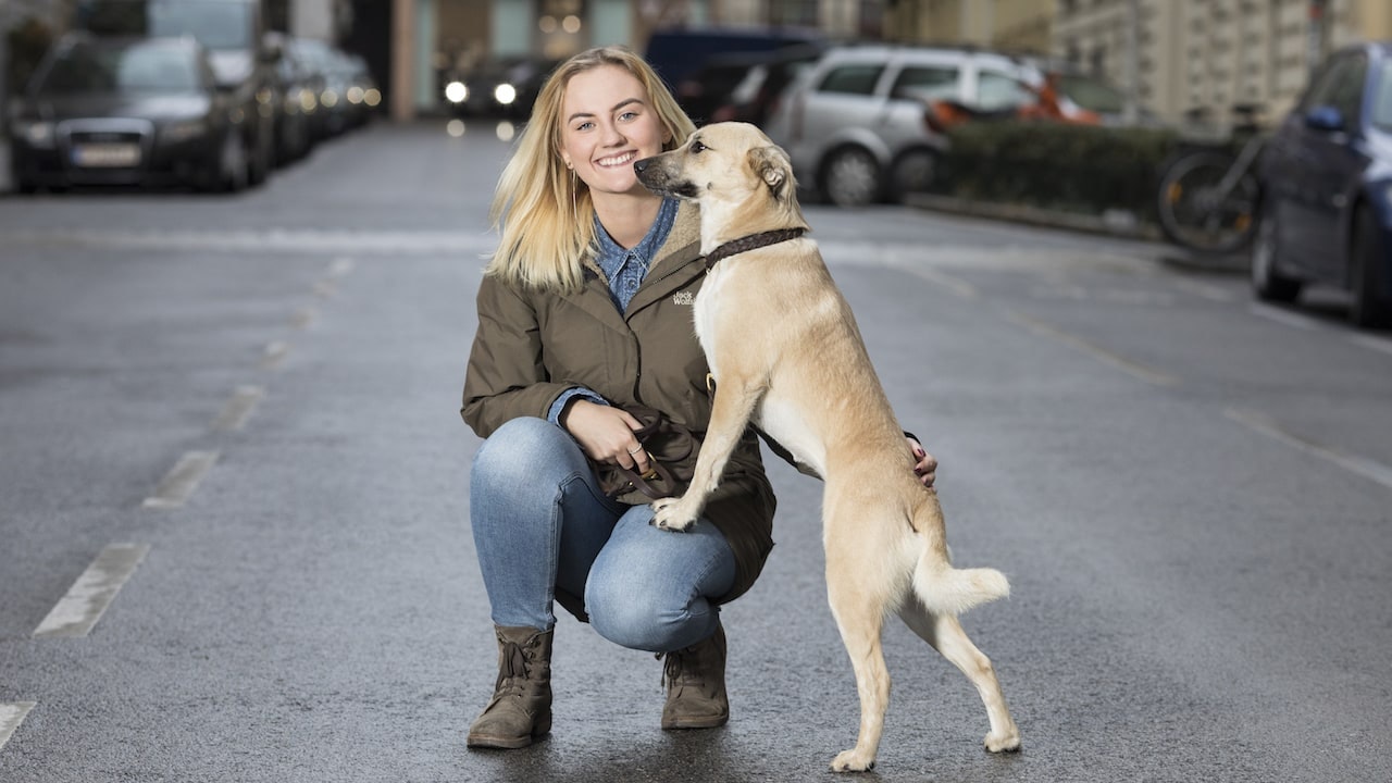 Jacqueline Pregesbauer auf einer Straße mit ihrem Hund Margot.