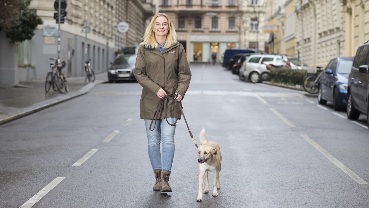 Jacqueline Pregesbauer walking her dog on a street.