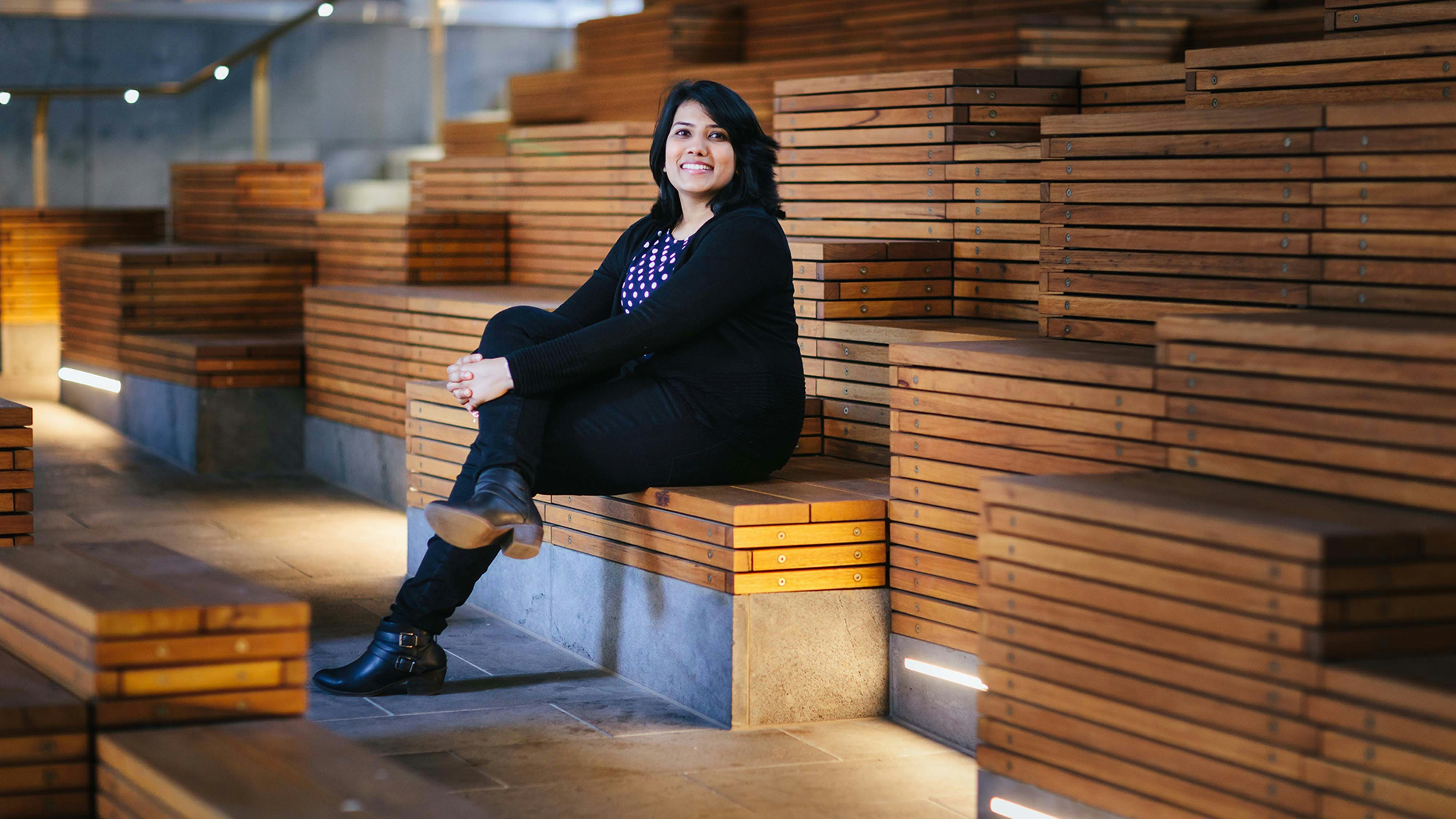 Femila Jesline sitting on a wooden bench