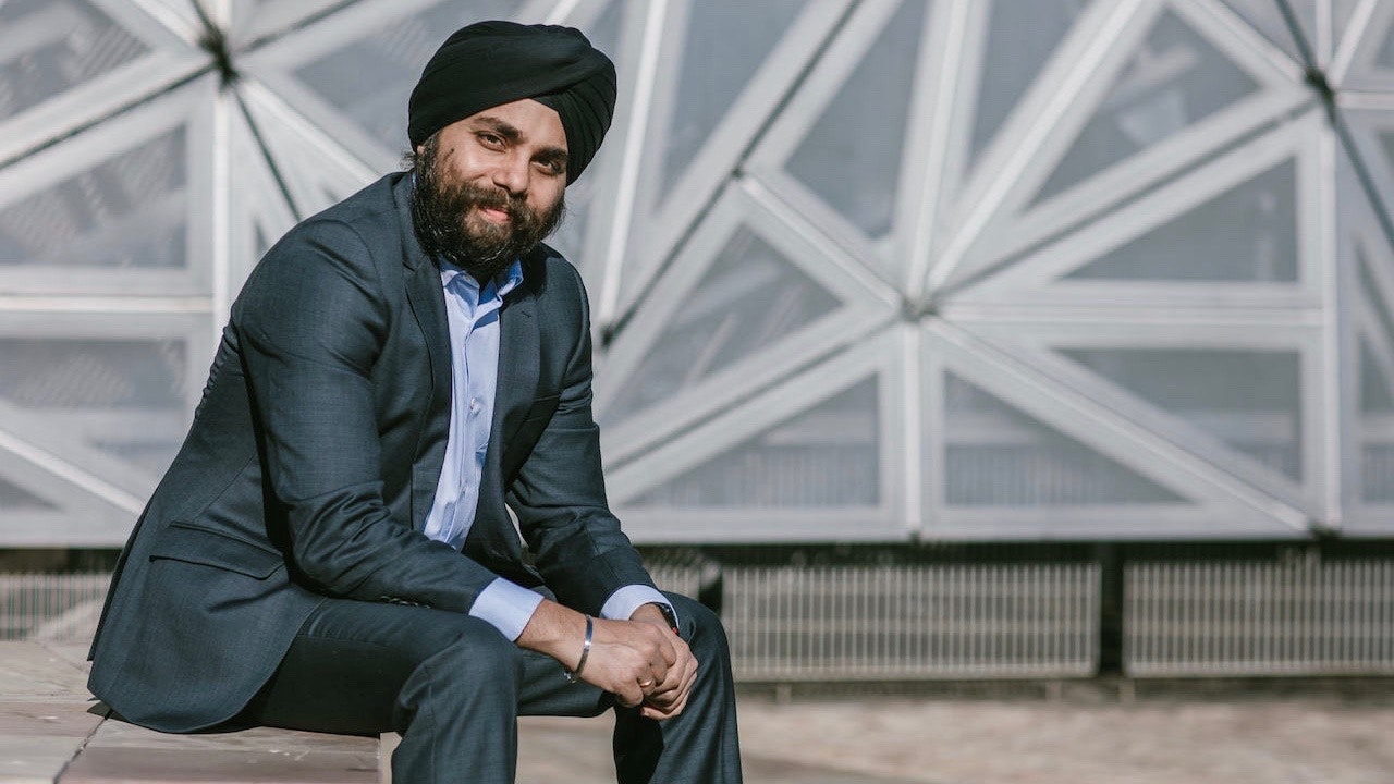 Randeep Gandhi sitting and slightly smiling towards the camera.