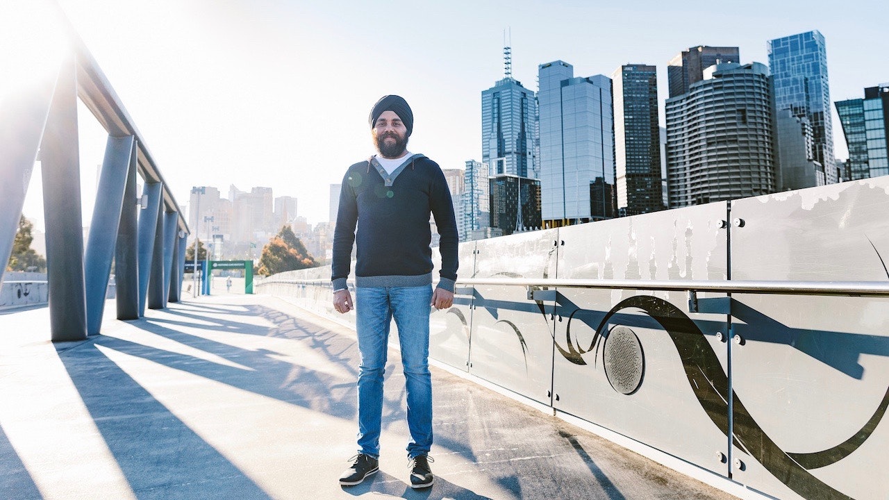 Randeep Gandhi outside with Melbourne skyline behind him.