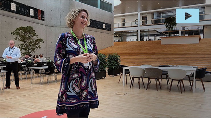 A Stibo employee gives a speech in a large hall.