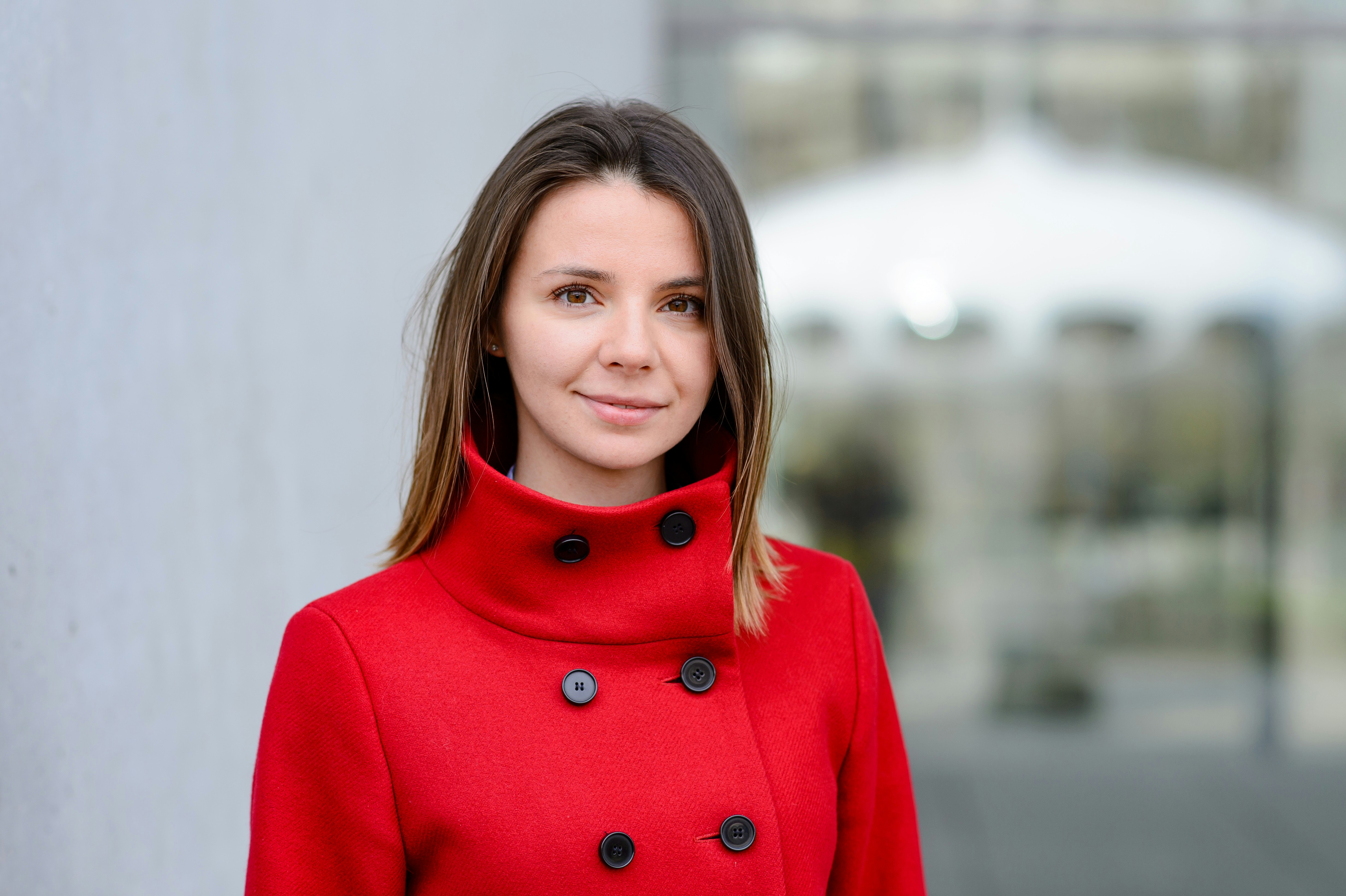 Profilfoto von Zoia Bylinovich in leuchtend rotem Mantel.