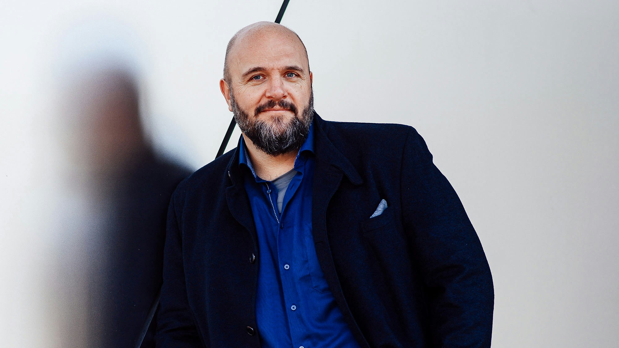 Profilfoto von Stefan Kotulla, der in einem dunkelblauen Hemd und einer offenen Anzugsjacke direkt in die Kamera schaut.