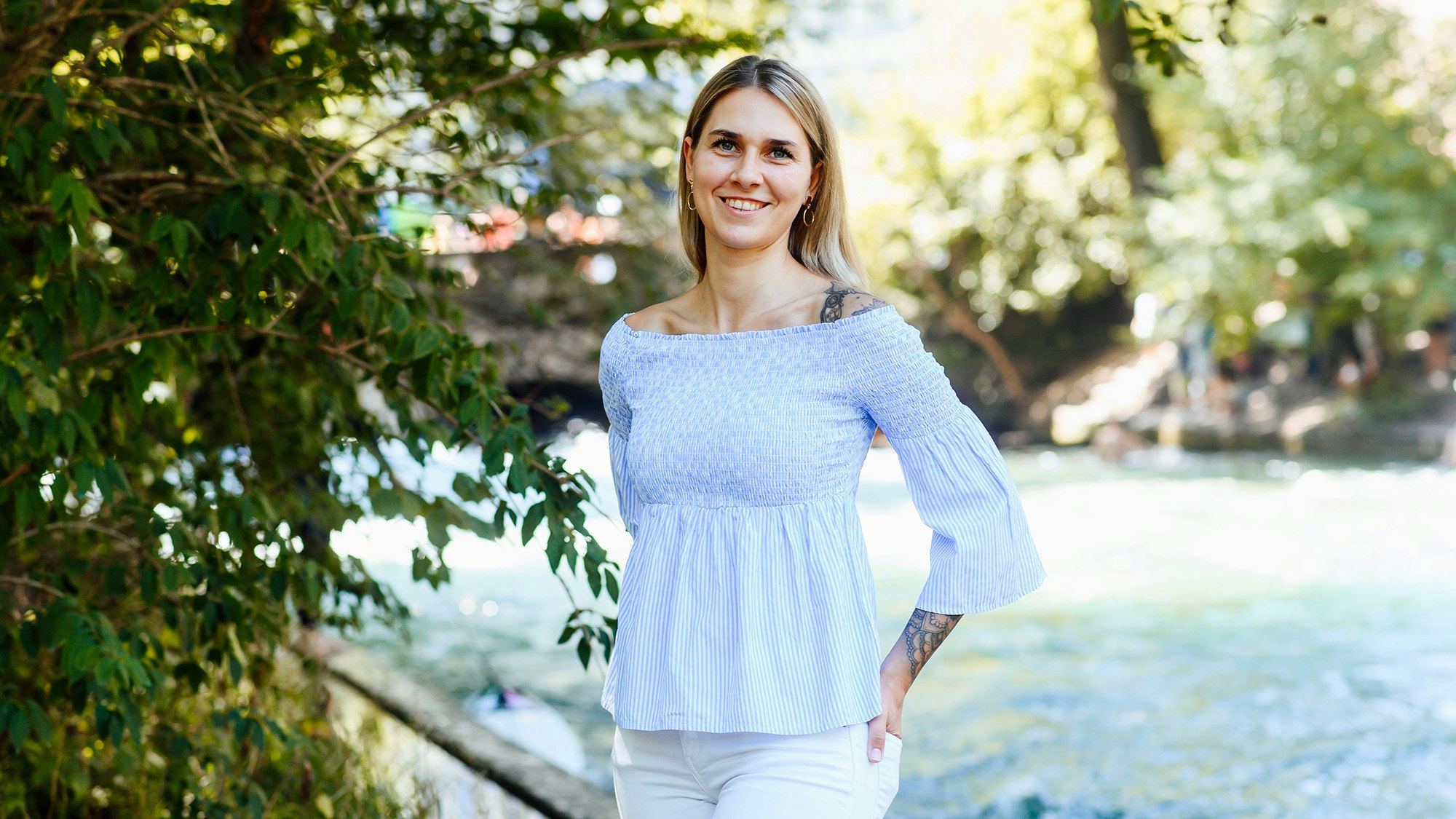 Victoria Schuppan outside in a summer park, looking towards the camera.