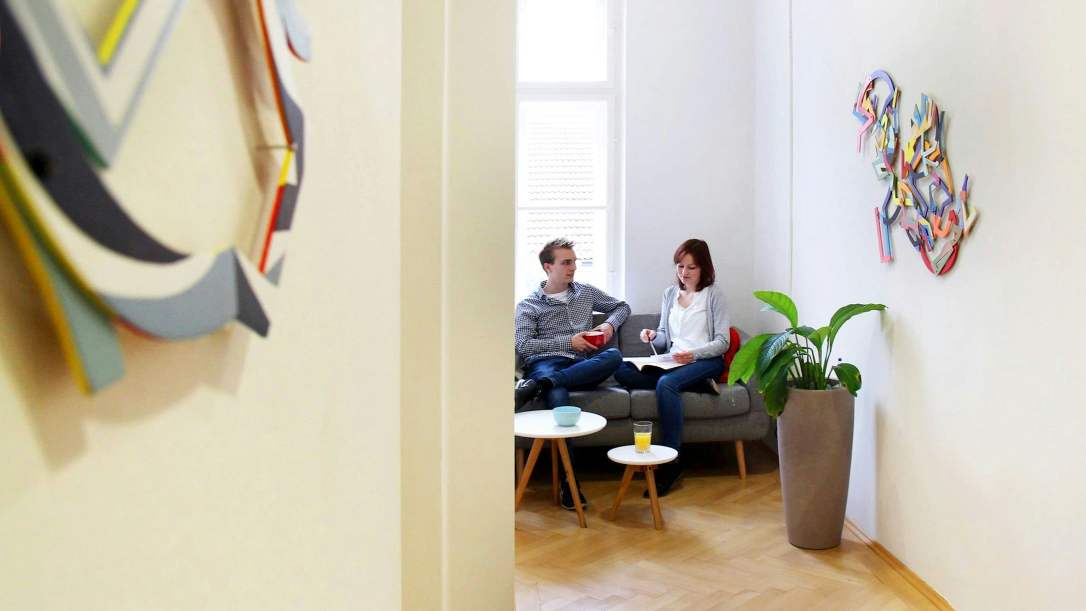 Two people working in an office, surrounded by arts