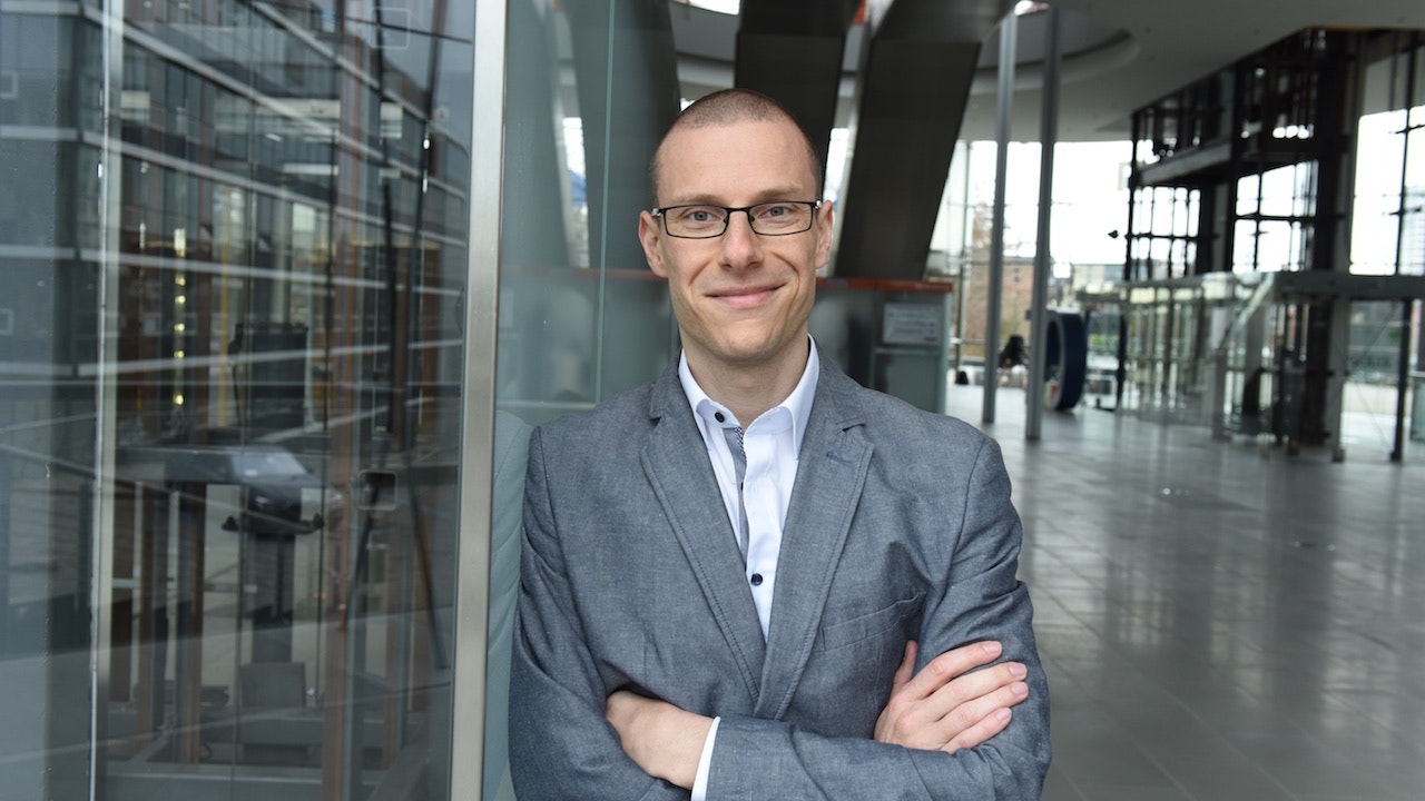 Benjamin Walter in a suit, in a modern office.