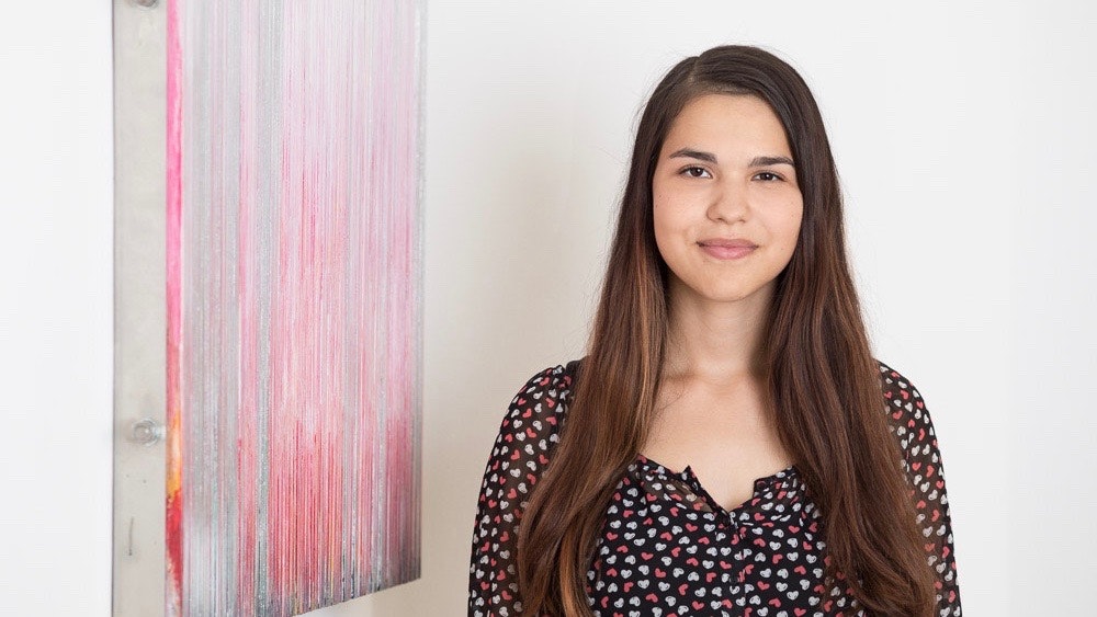 Sabine is standing in front of a colorful work of art.