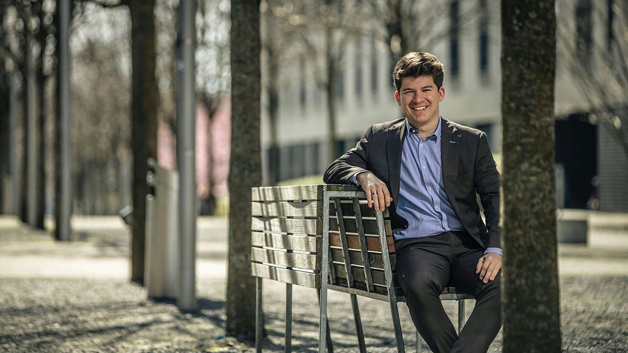 Tobias sitzt auf einer Parkbank