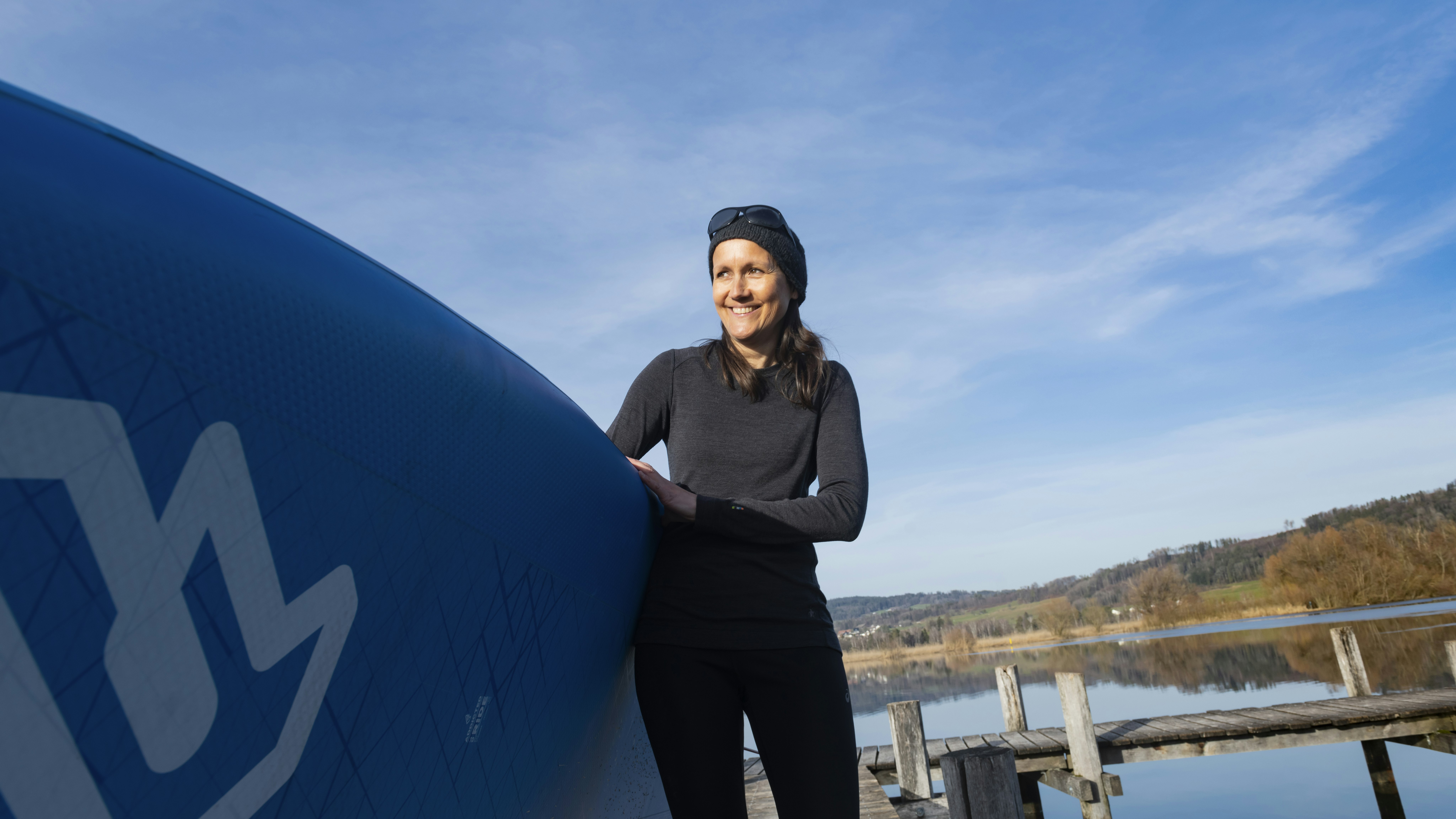 Claudia carrying a surfboard