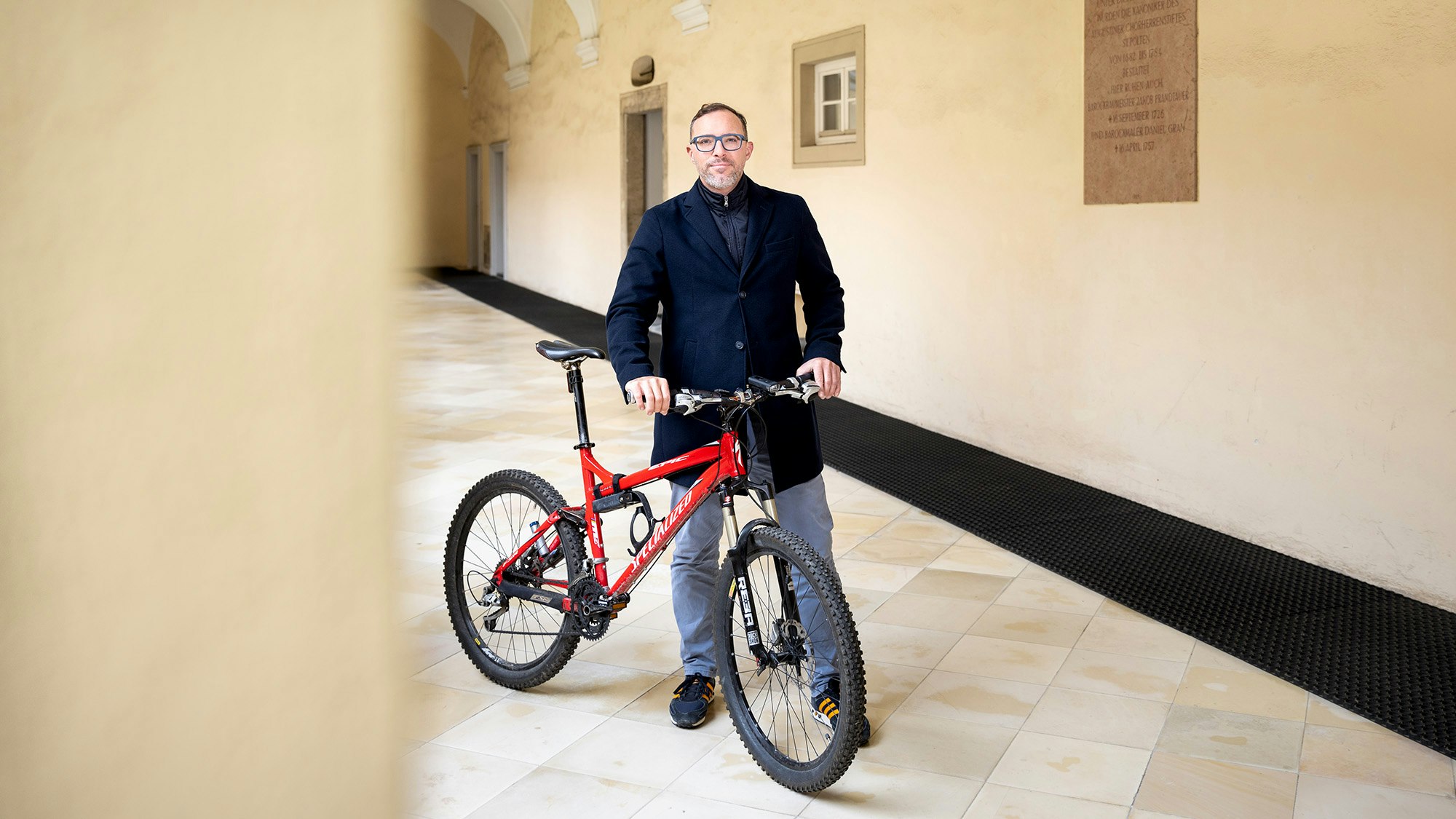 Gernot hält sein Fahrrad in einer Halle