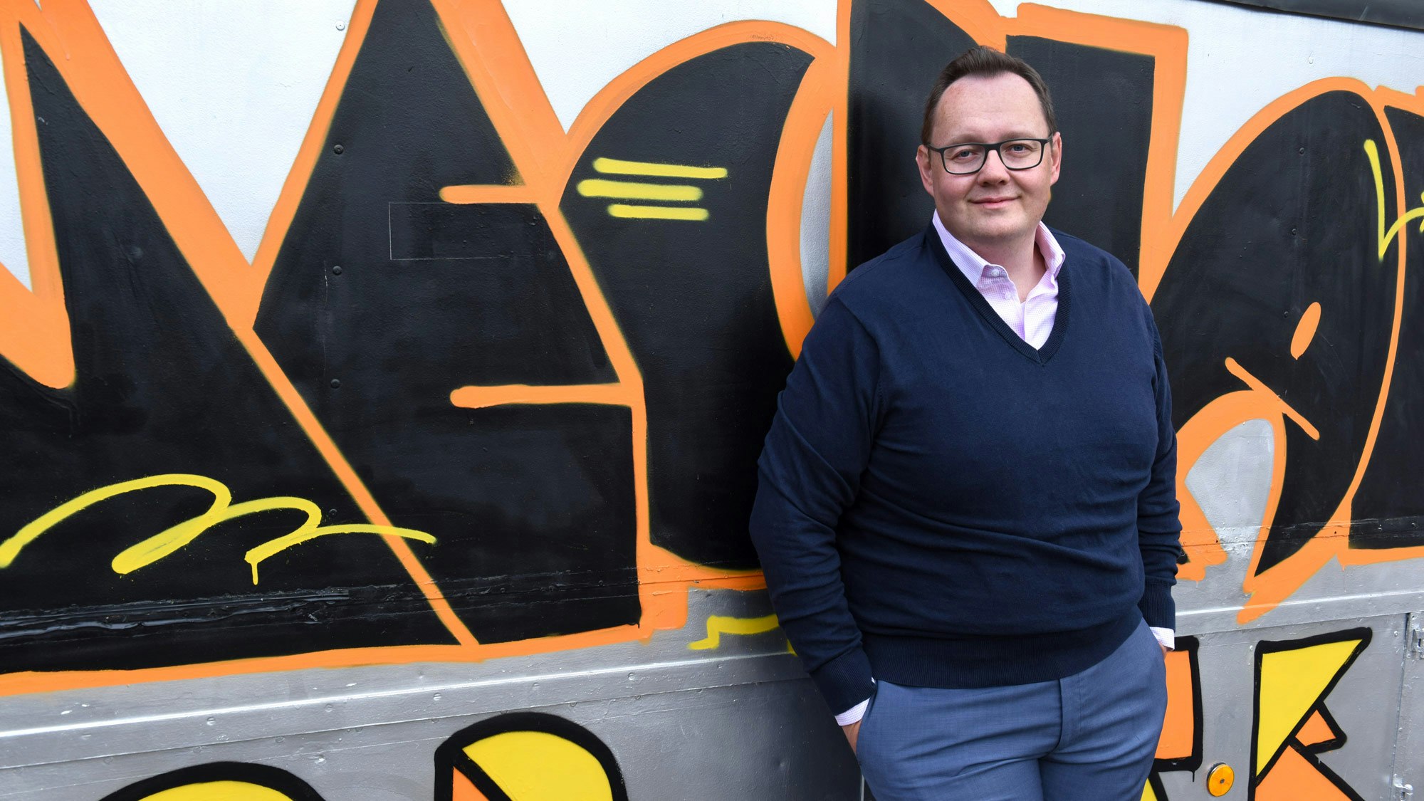 Martin in front of a graffiti wall