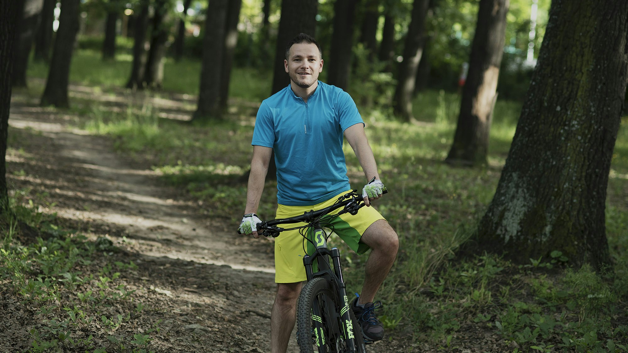 Nikolay on top of his bicycle in the middle of a forest