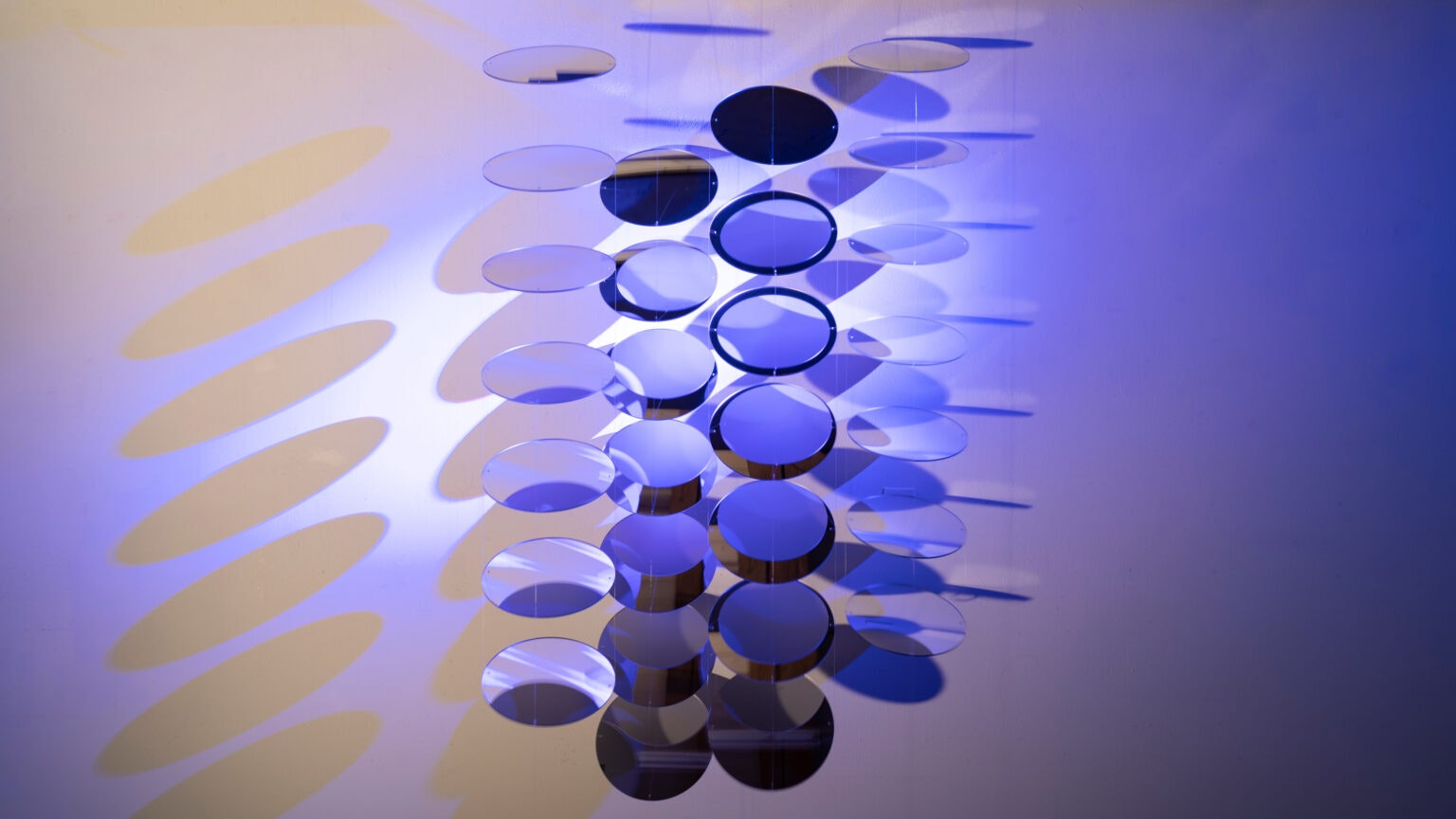 Kunstwerk met kleine schijfjes die gedeeltelijk transparant zijn in de dominante kleur blauw van Michaela Lautenschlager.