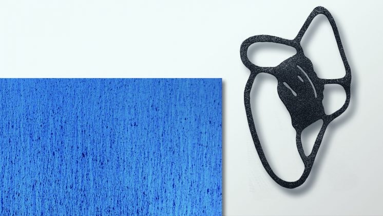 Kunstwerk - rechthoekig stuk met blauw nerf patroon dat aan de muur hangt, links van een zwarte kunststof draadwerk kunst.