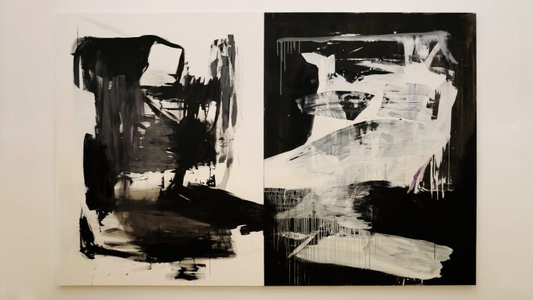 Een schilderij gesplitst in twee met abstracte figuren in wit op zwart geïnverteerd