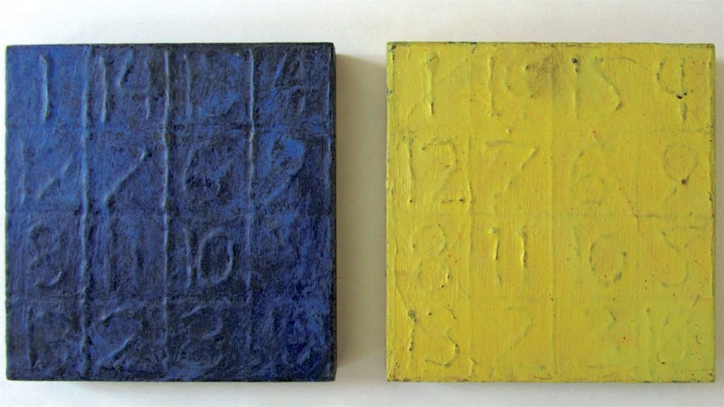 Two art pieces - dark blue and bright yellow squares with embossed numbers in a grid.