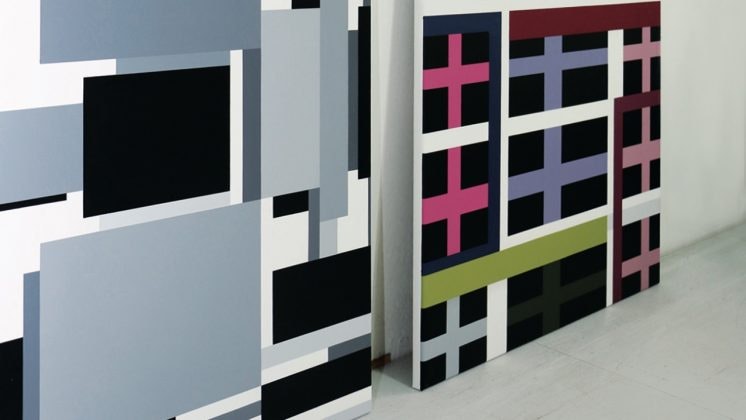 Two paintings of clean geometric lines, one of only black and white, the one on the right with colourful filling.