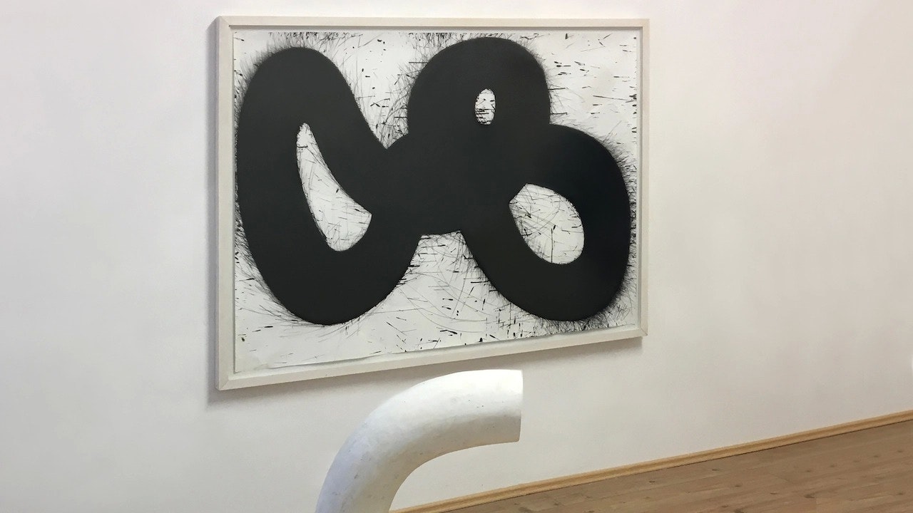 Large painting hanged on a wall. The painting has an abstractly shaped black ribbon.