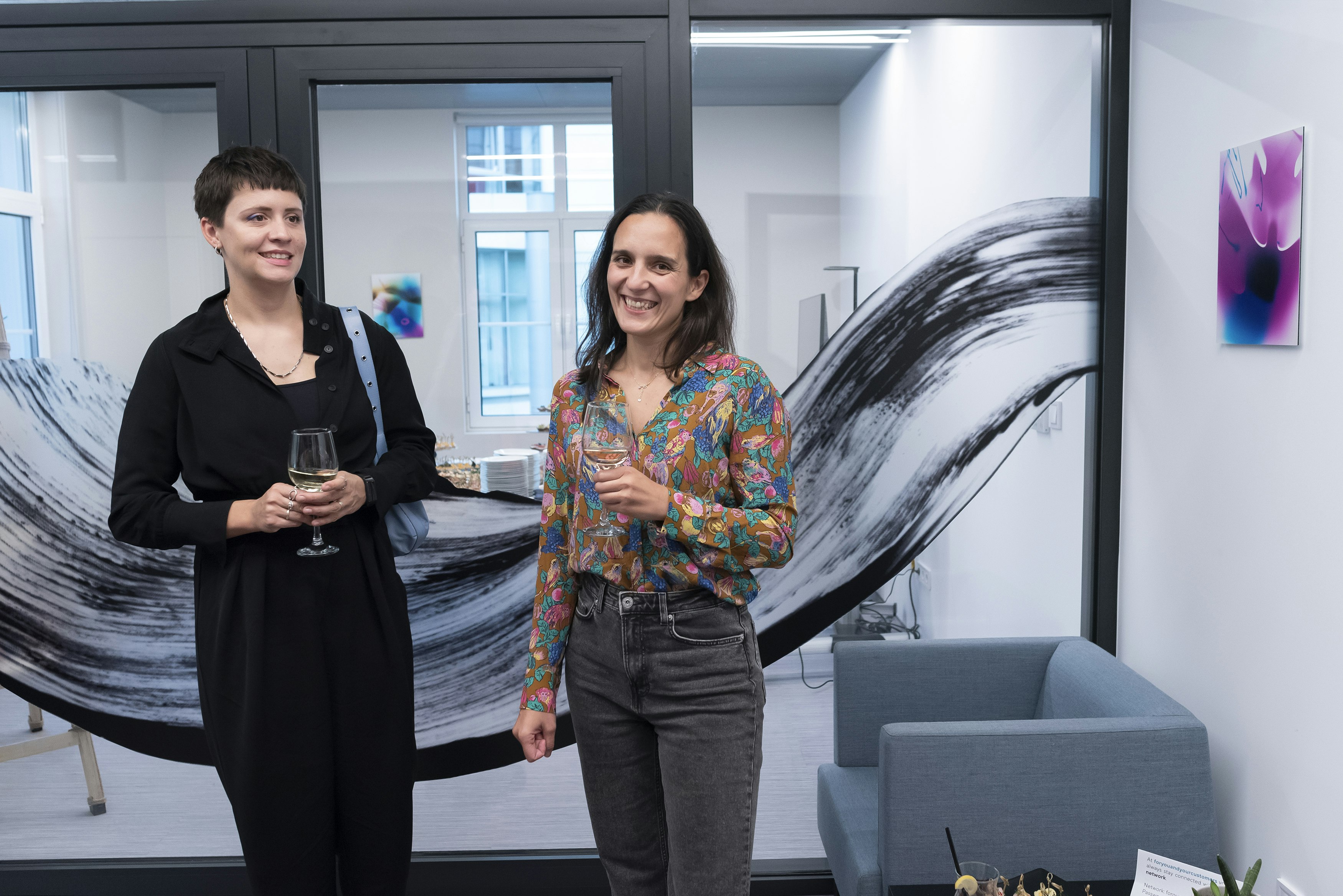 Two women standing next to art.